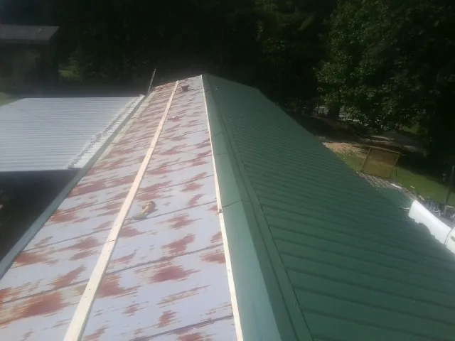 Old rusted panels beside newly installed green metal roofing — Wind Damage Roof Repair by Roofing Brothers in Hopewell