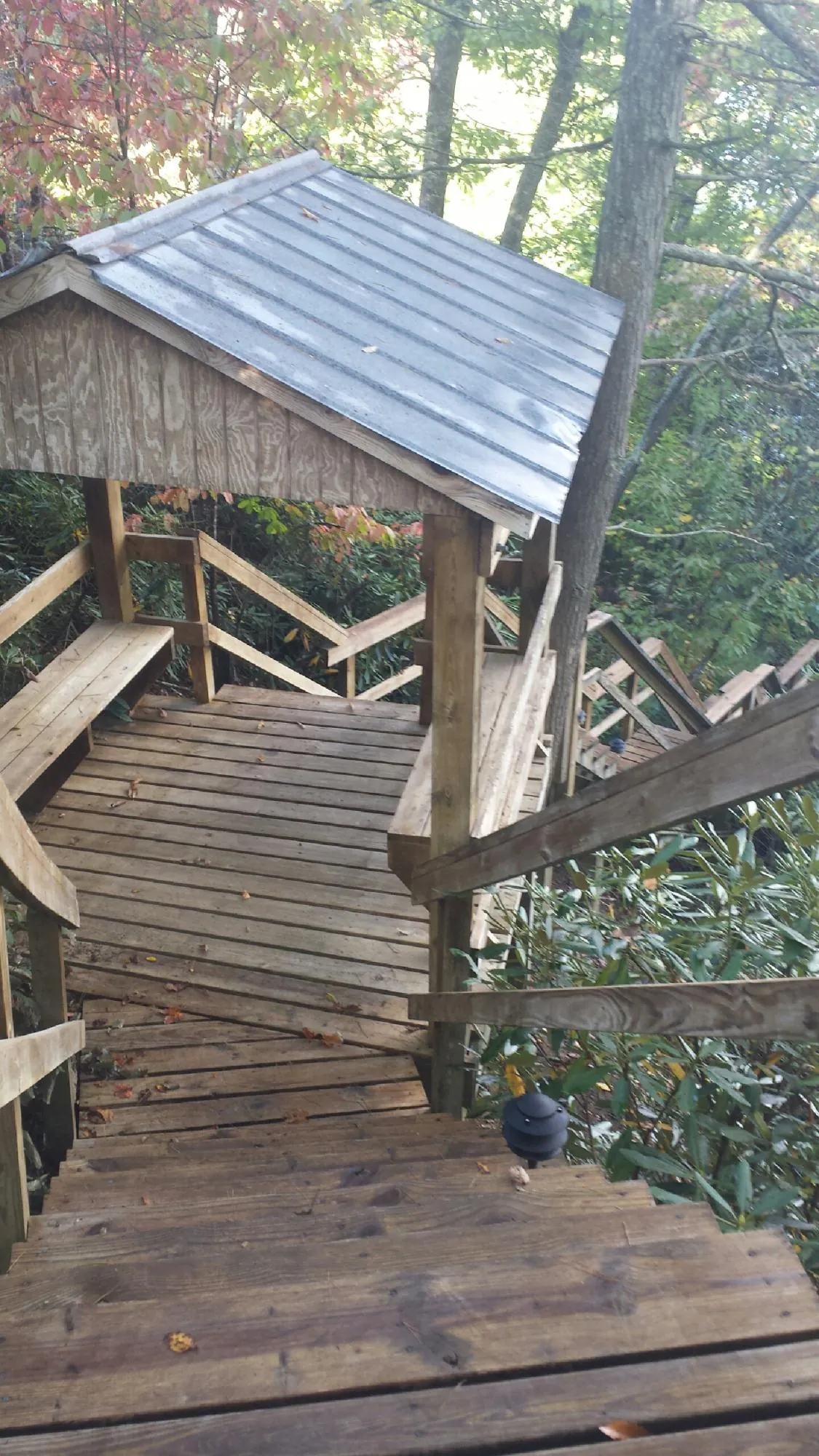 Metal roofed shelter over wooden steps on a wooded walkway — Skylight Repair & Installation work by our crew in Hopewell